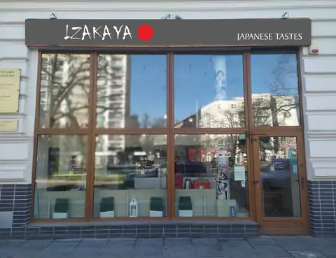 Witryna lokalu z czarnym szyldem IZAKAYA