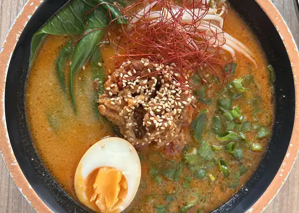 Ramen z jajkiem, chashu i wakame w czarno-pomarańczowej misce